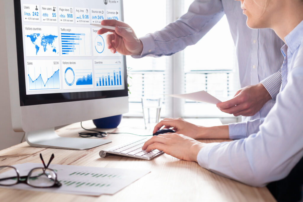 Team of business people discussing digital marketing metrics report and return on investment strategy for advertisement campaign data analytics dashboard on computer screen in office | Marketing Direction | Digital Marketing Agency | Tampa - St Pete FL