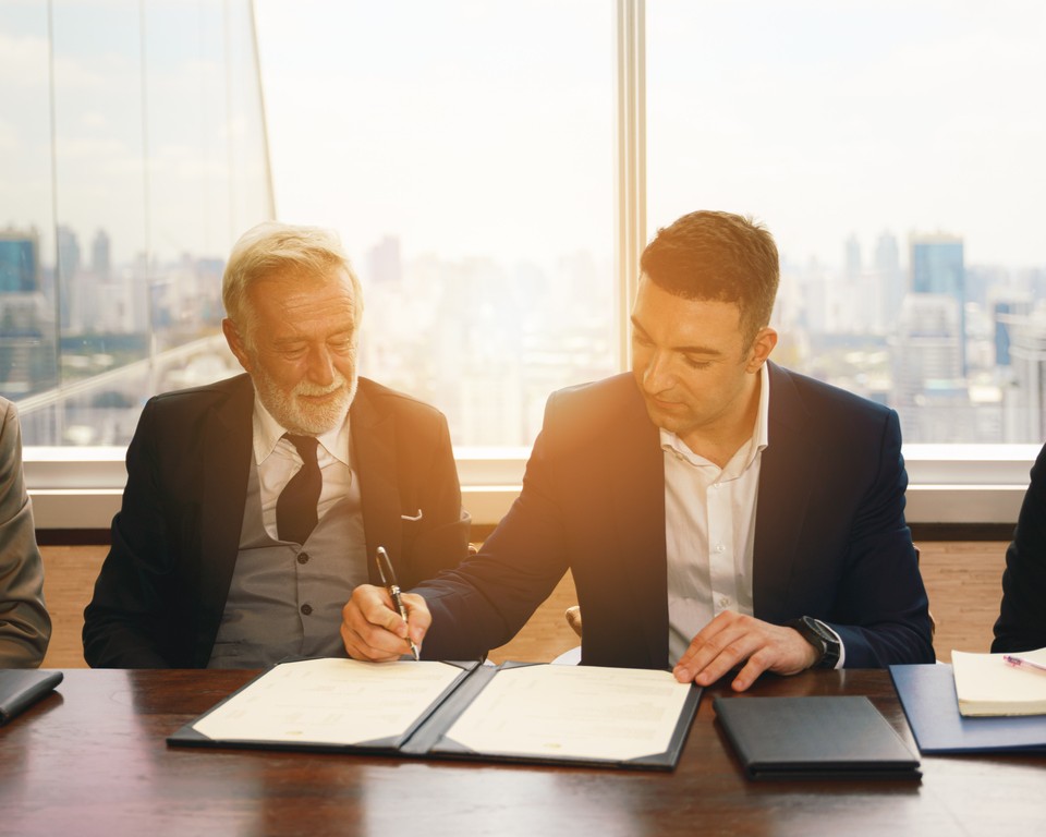 Recurring Revenue Contract Negotiation Business professionals reviewing recurring revenue model and service agreement